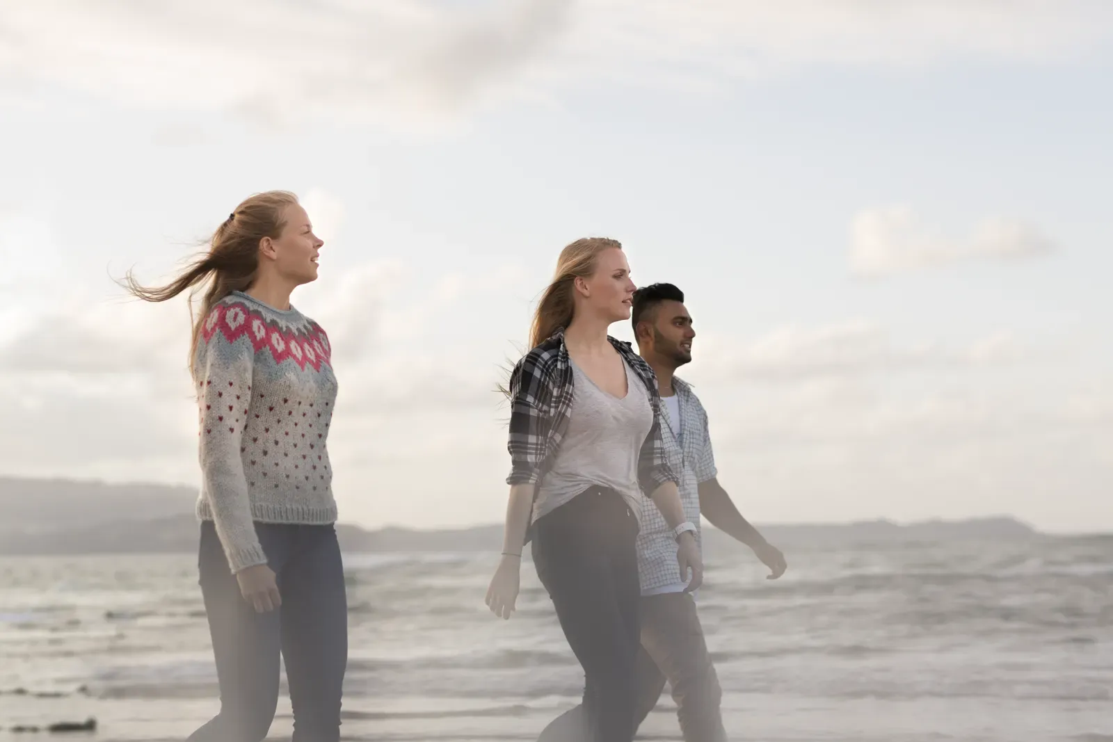 Students walking along a New Zealand beach